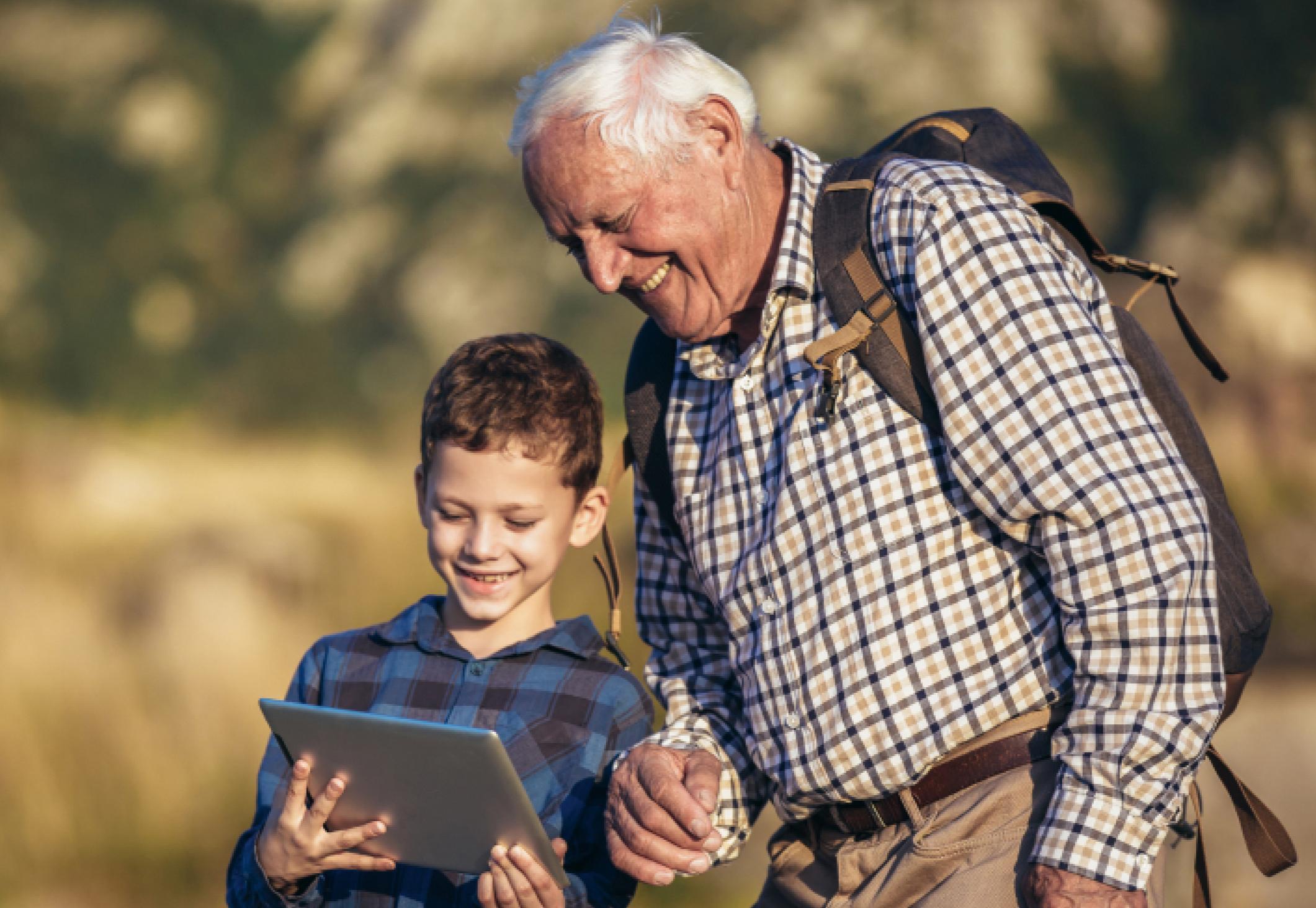 Elderly man and grandson looking at tablet